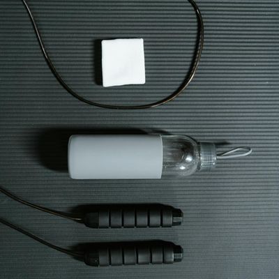 Water bottle and towel on a black training mat